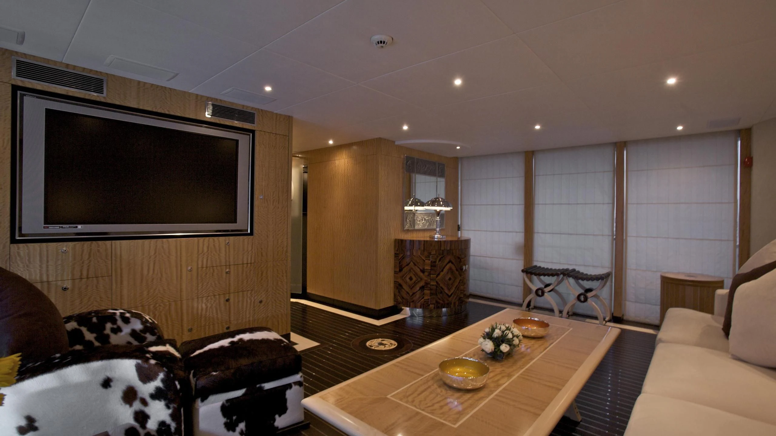 a living room with a tv and a table aboard ACHILLES Yacht for Sale