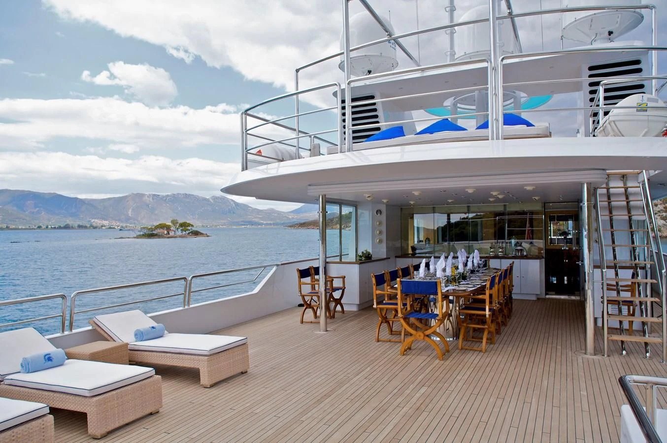 a deck with a table and chairs on it aboard ACHILLES Yacht for Sale