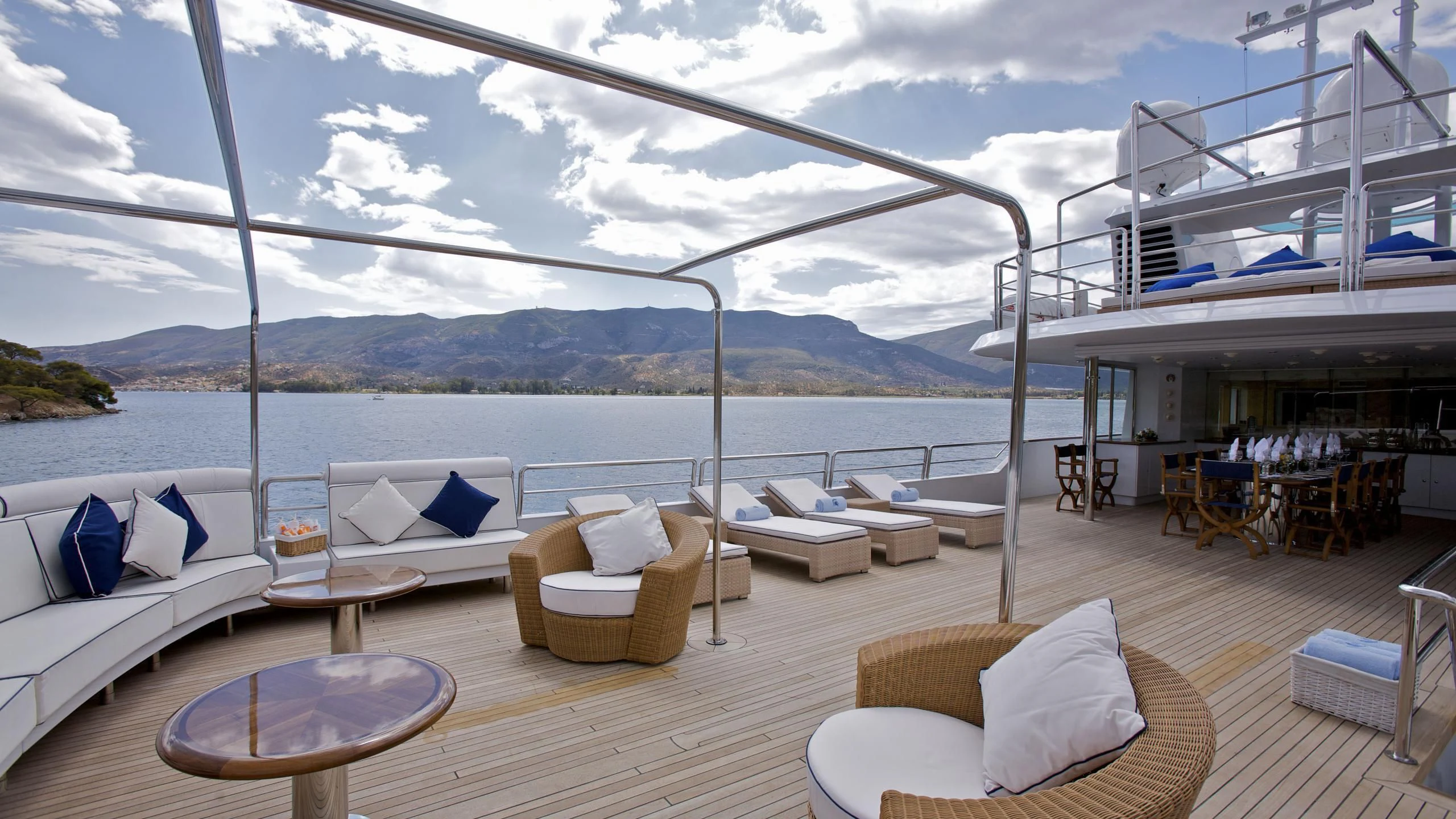 a deck with a view of the ocean and mountains aboard ACHILLES Yacht for Sale
