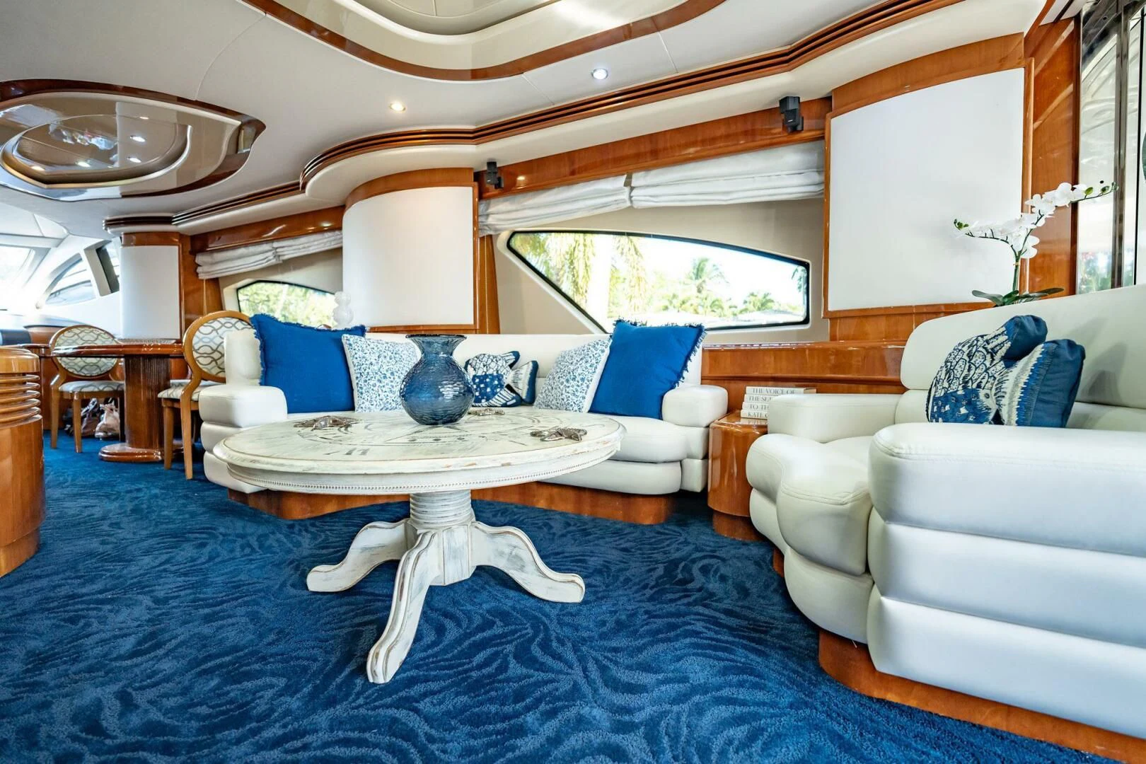 a living room with a large blue rug and white couches aboard THE CURE Yacht for Sale