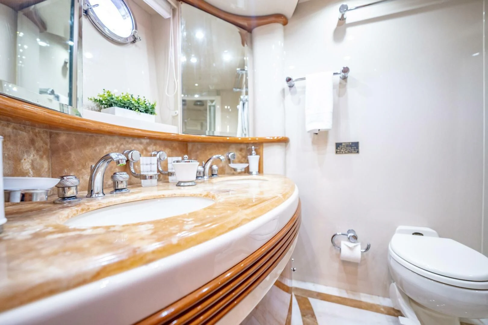 a bathroom with a sink toilet and a mirror aboard THE CURE Yacht for Sale