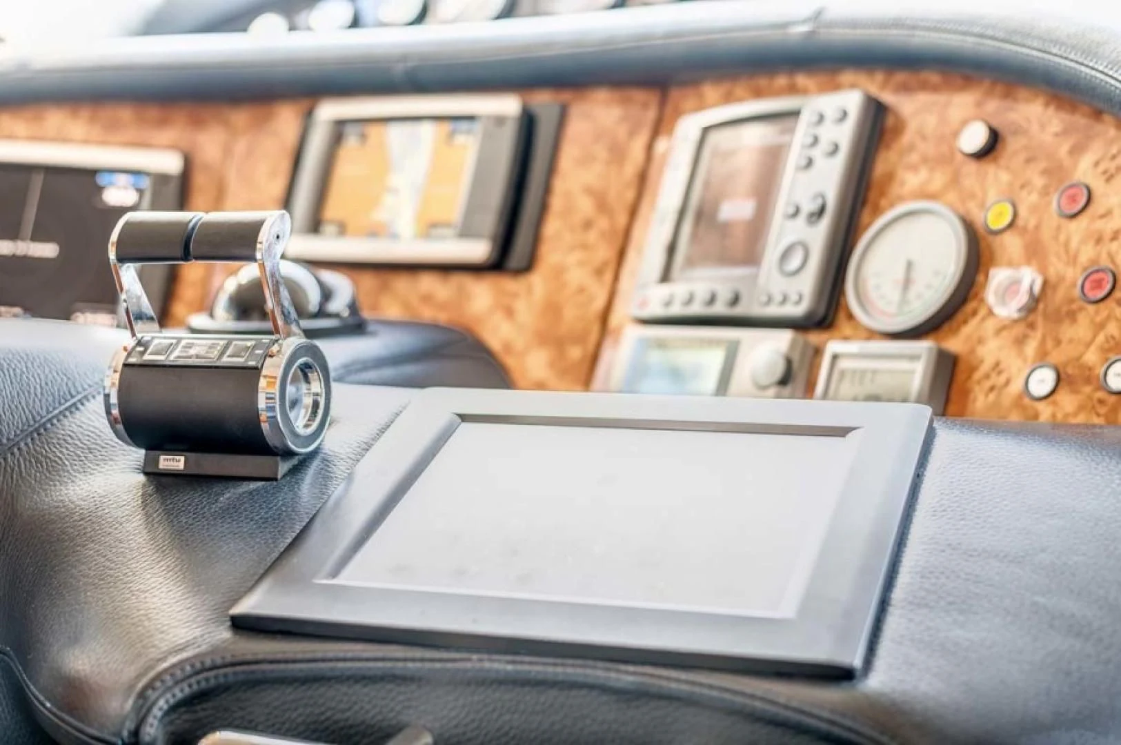 a watch and a laptop on a leather couch aboard THE CURE Yacht for Sale