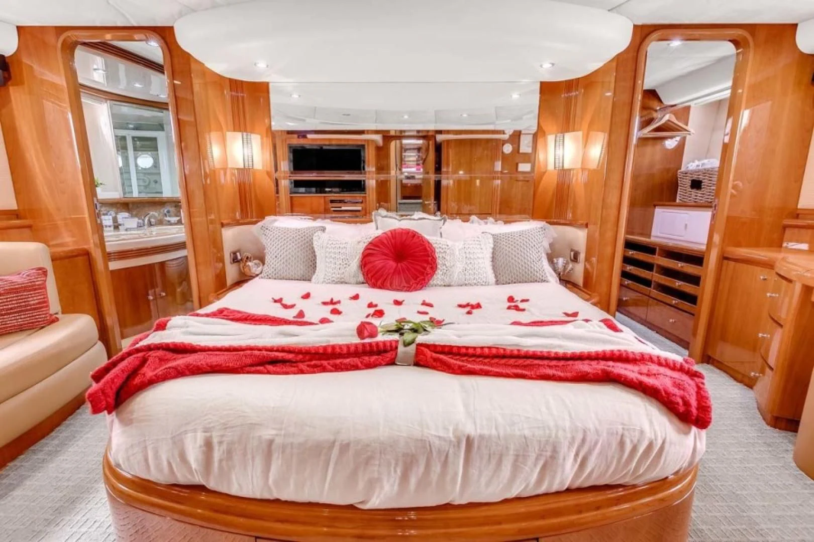 a bed with red and white sheets aboard THE CURE Yacht for Sale