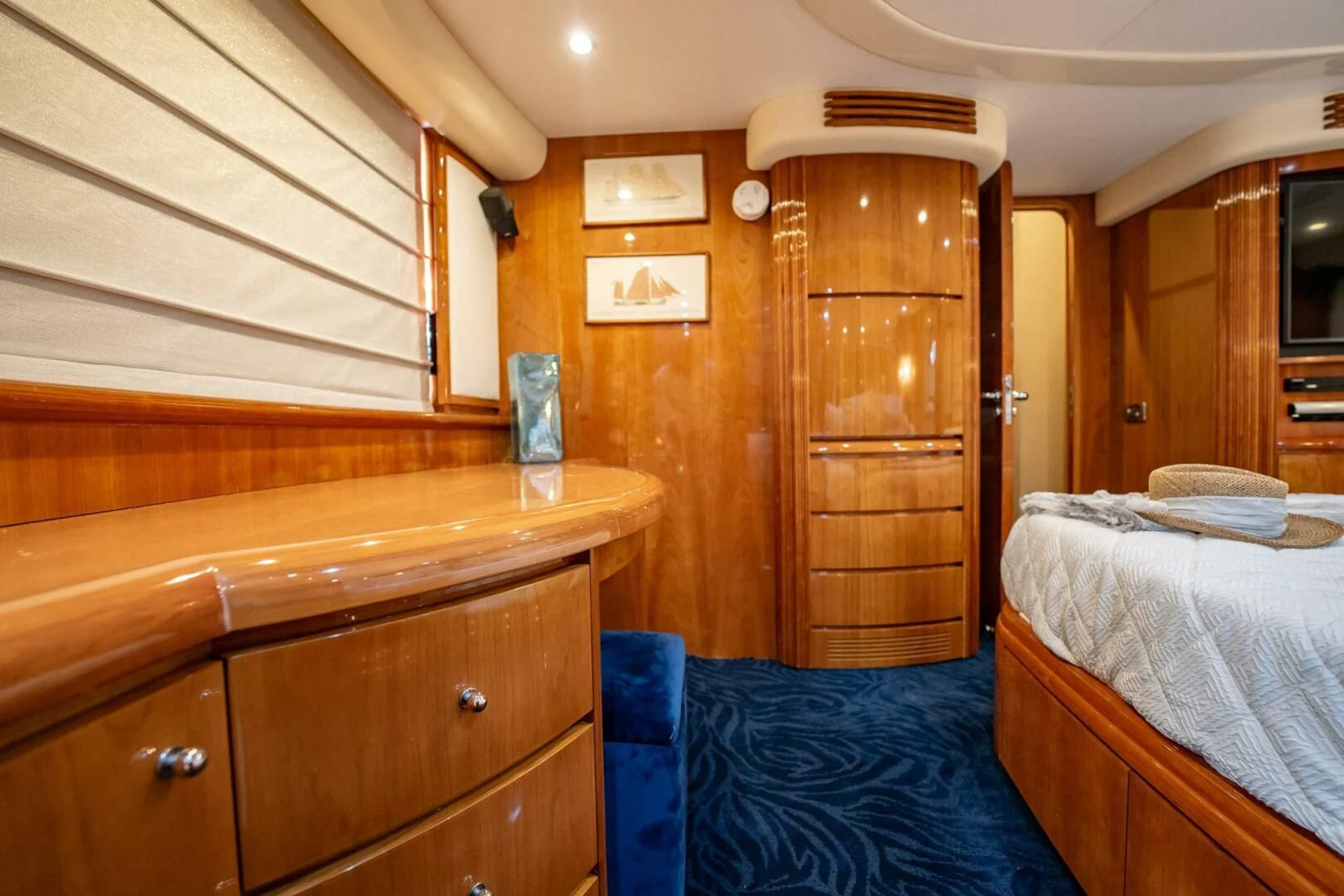a bedroom with wooden cabinets aboard THE CURE Yacht for Sale
