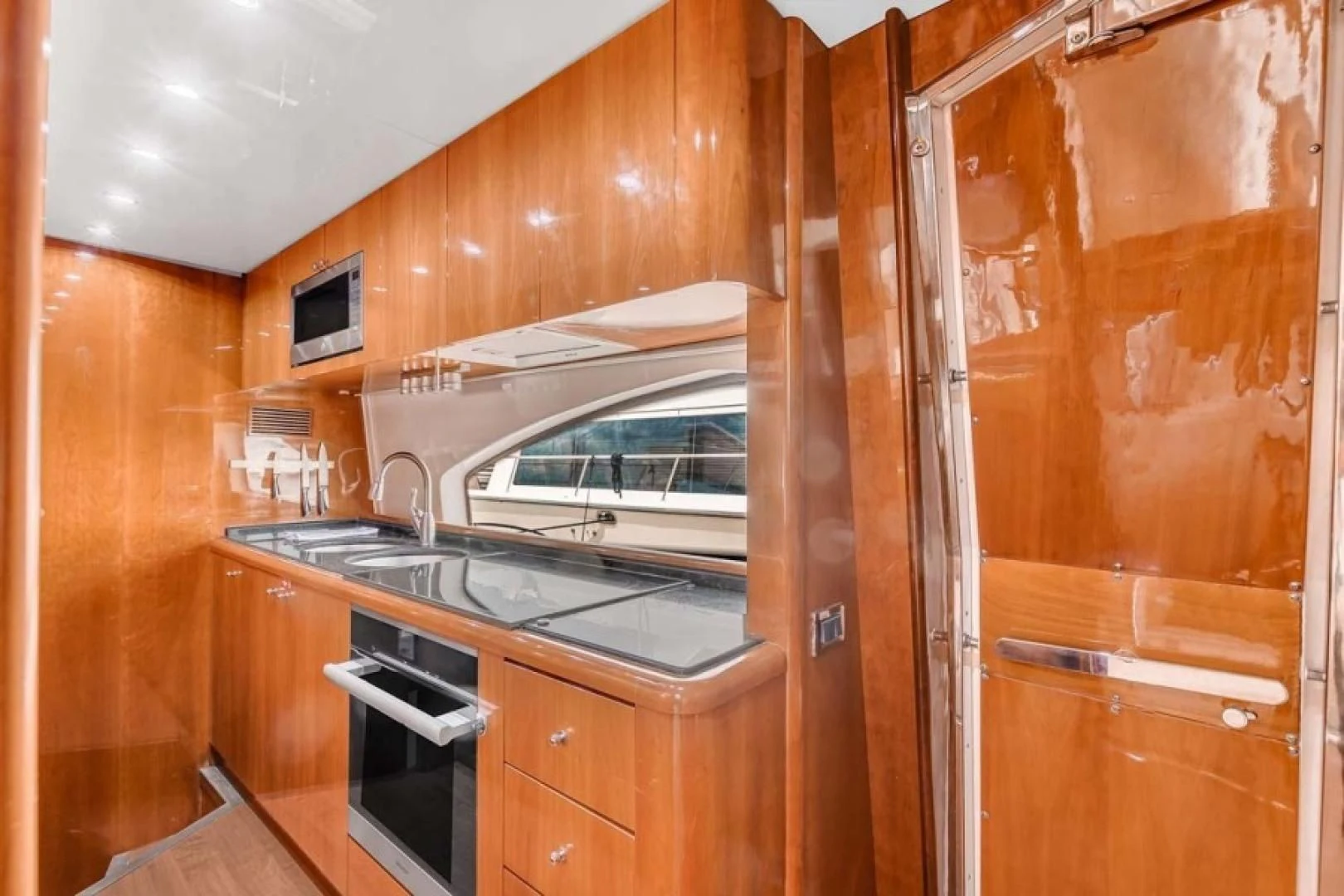 a kitchen with wooden cabinets aboard THE CURE Yacht for Sale