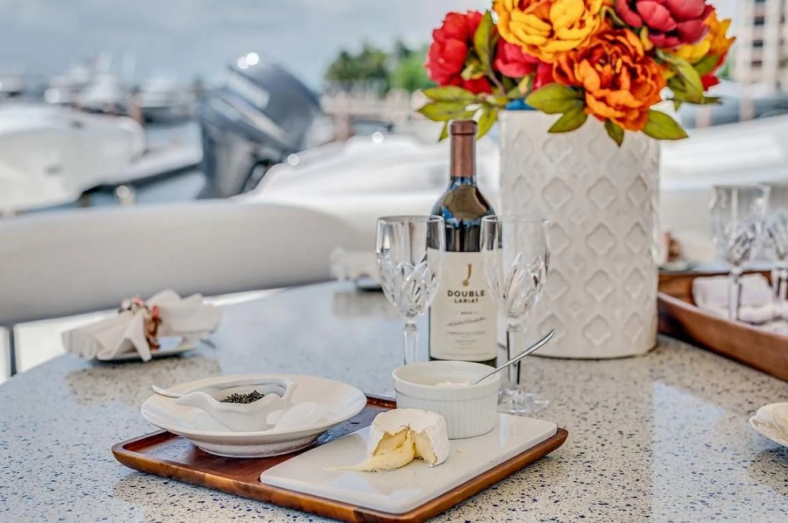 a table with a vase and a bottle of wine aboard THE CURE Yacht for Sale