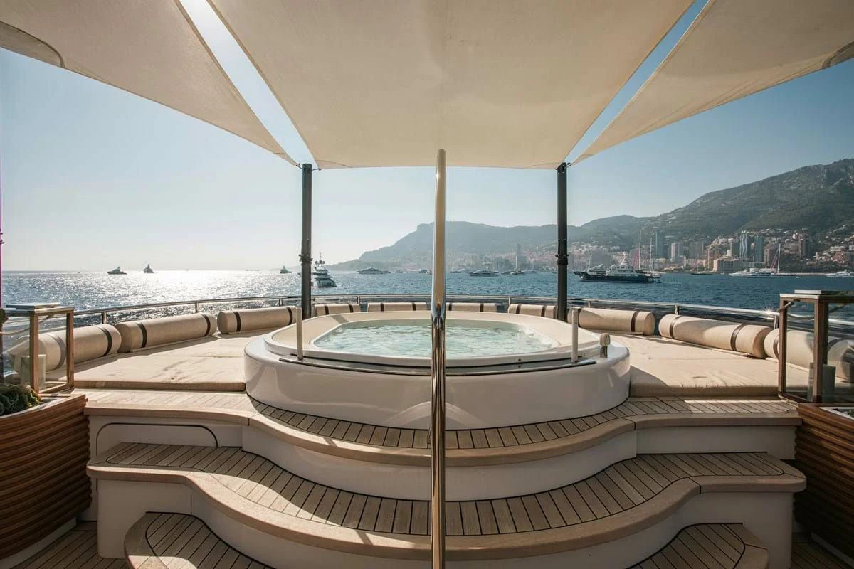 a large white pool with a view of a city and mountains in the background aboard MY SECRET Yacht for Sale