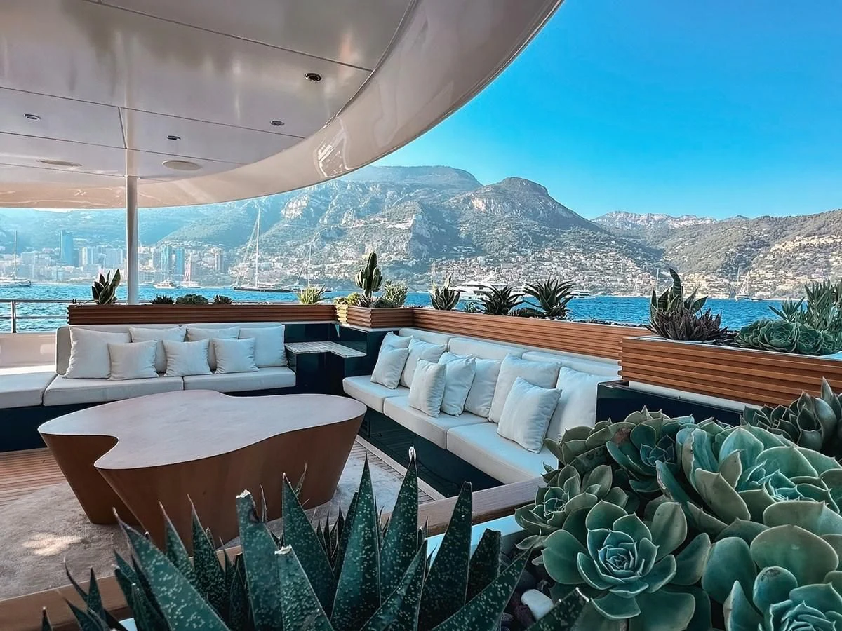 a patio with a large body of water and mountains in the background aboard MY SECRET Yacht for Sale