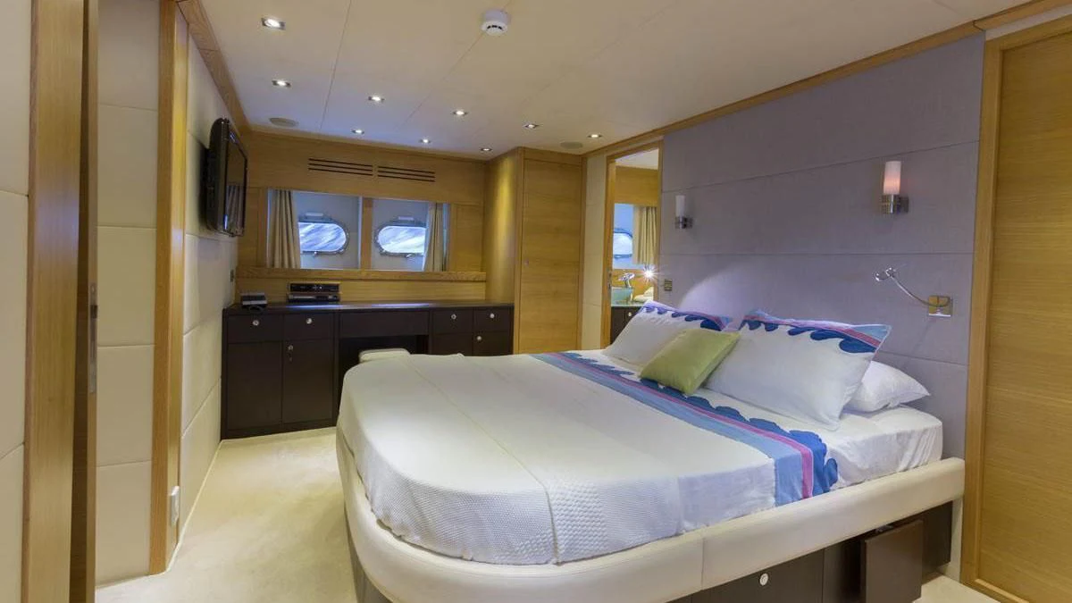 a room with a bed and a desk aboard GOOD VIBES Yacht for Sale