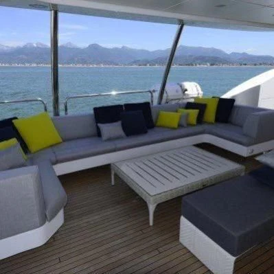 a deck with a couch and a large body of water in the background aboard GOOD VIBES Yacht for Sale
