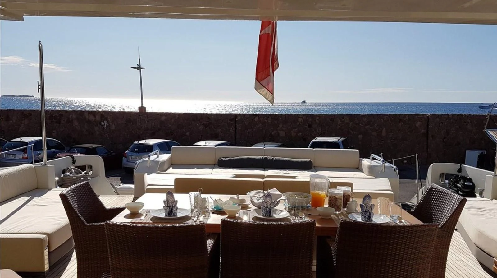 a table with chairs and a flag aboard PATRONESS Yacht for Sale