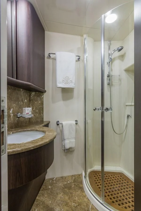 a bathroom with a shower sink and a mirror aboard NEXT Yacht for Sale