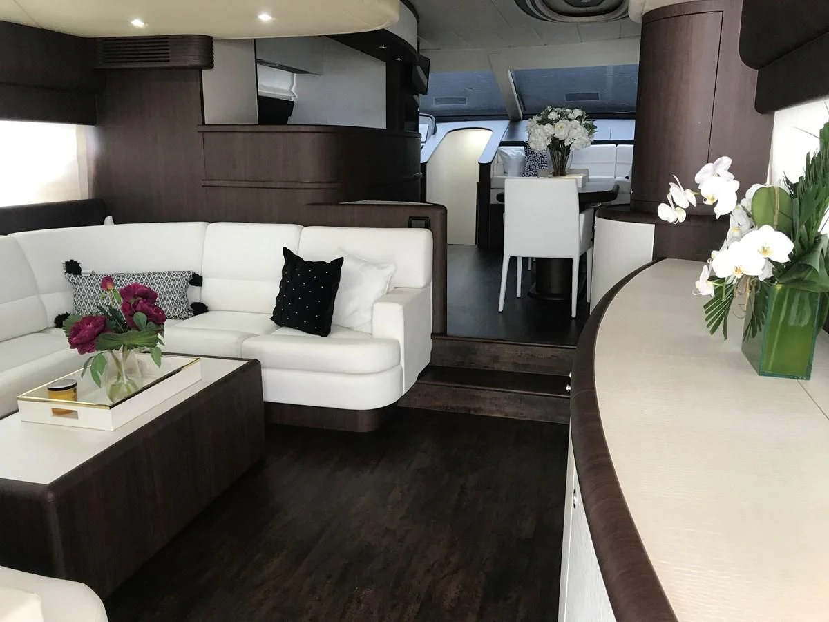 a living room with a white couch and a table with flowers aboard NEXT Yacht for Sale