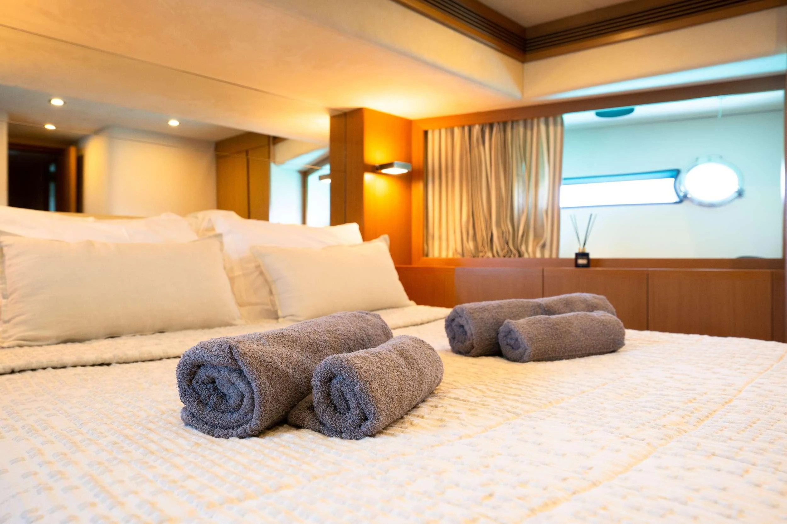 a bed with pillows aboard NINETEEN Yacht for Charter