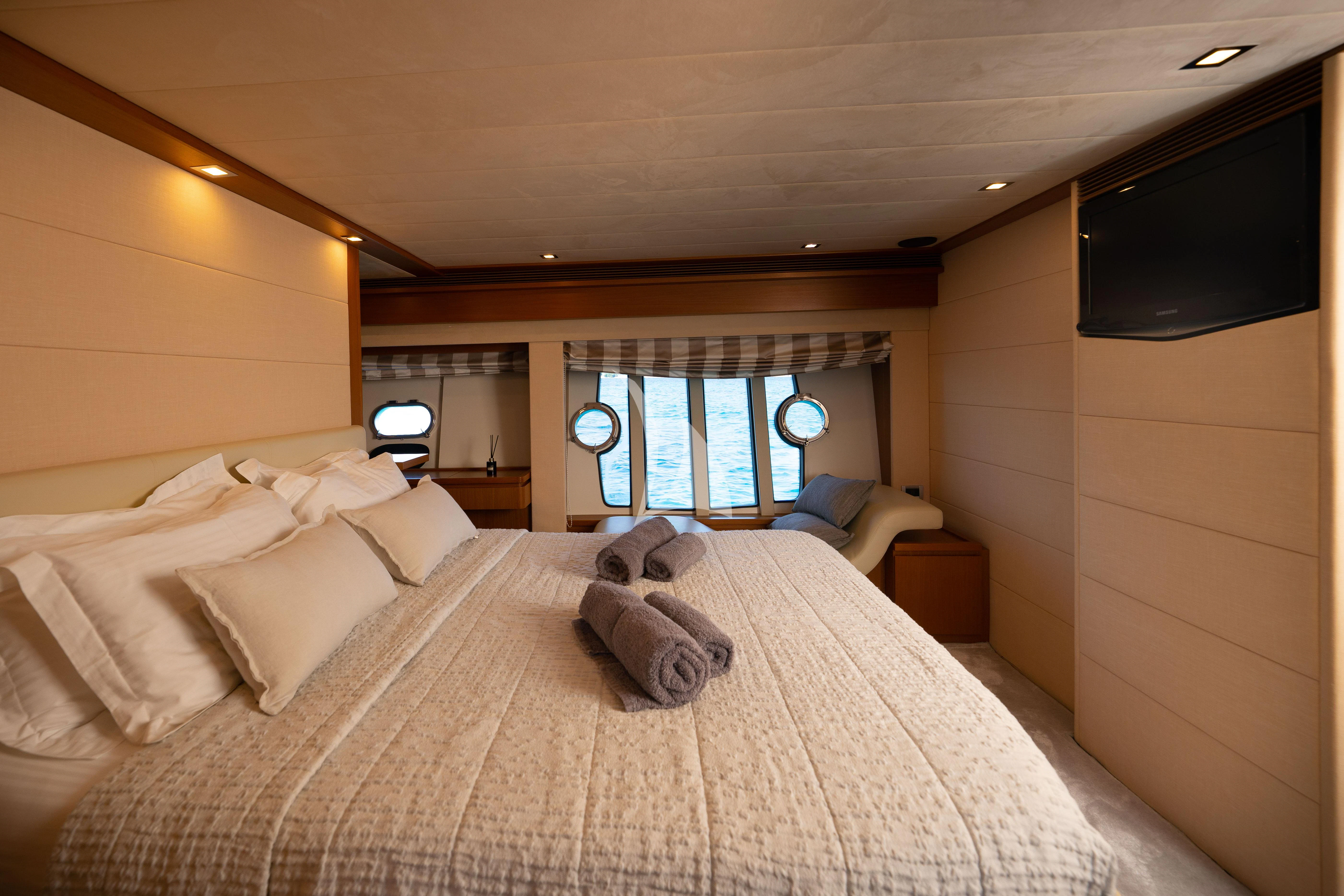 a room with a bed and a television aboard NINETEEN Yacht for Charter