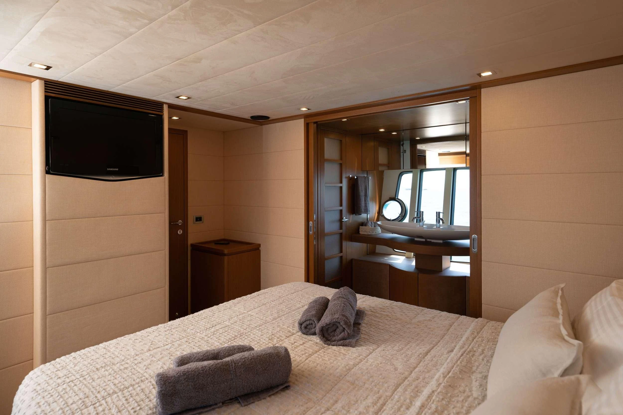 a hotel room with a bed and tv aboard NINETEEN Yacht for Charter