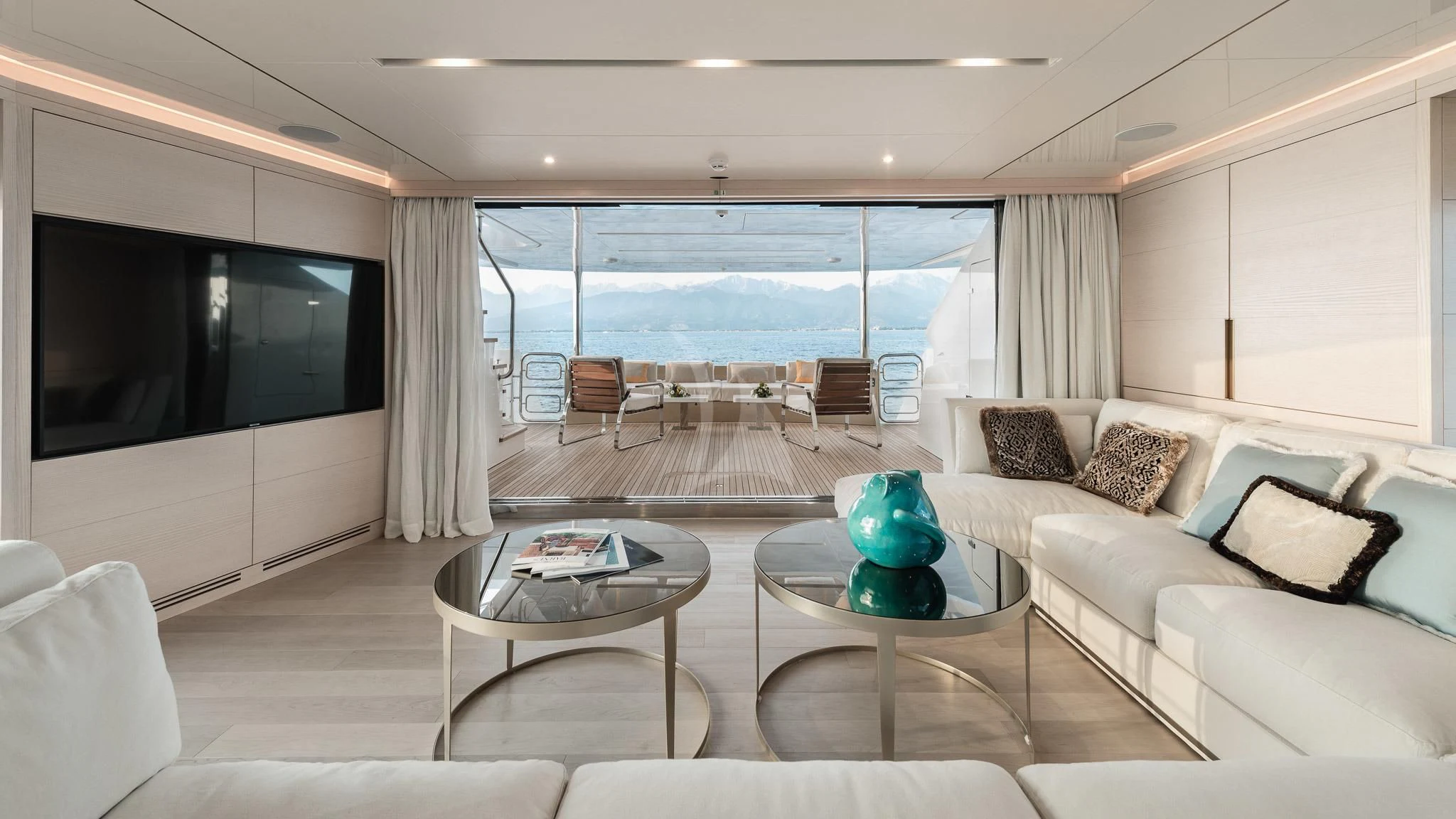 a living room with a large flat screen television and a table aboard KIMOJO Yacht for Sale