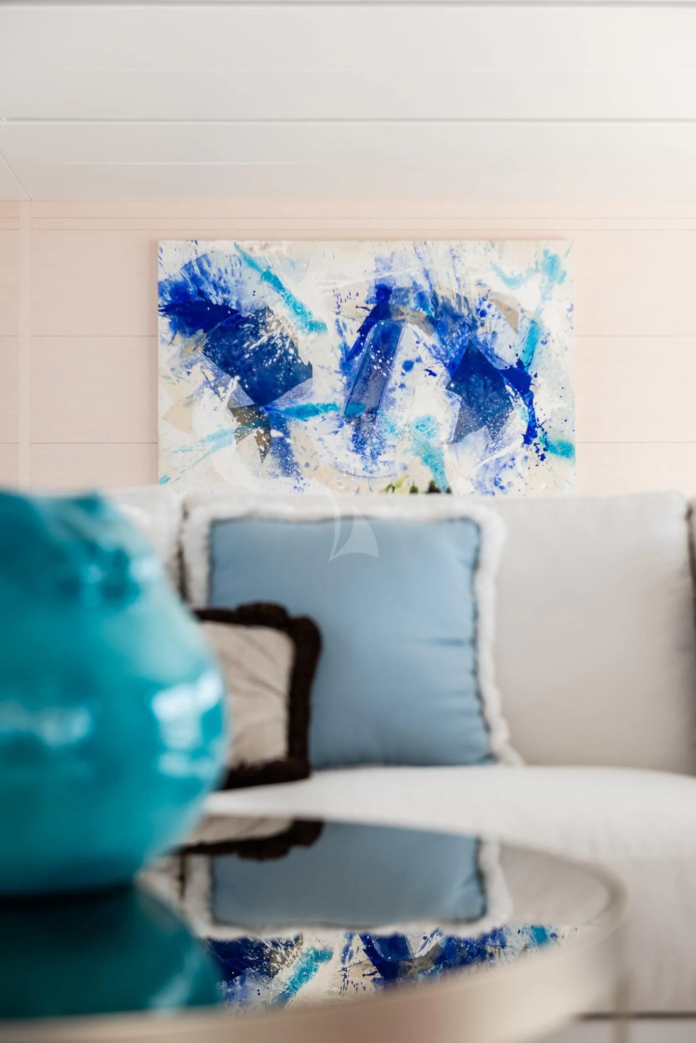 a couch with a painting on it aboard KIMOJO Yacht for Sale