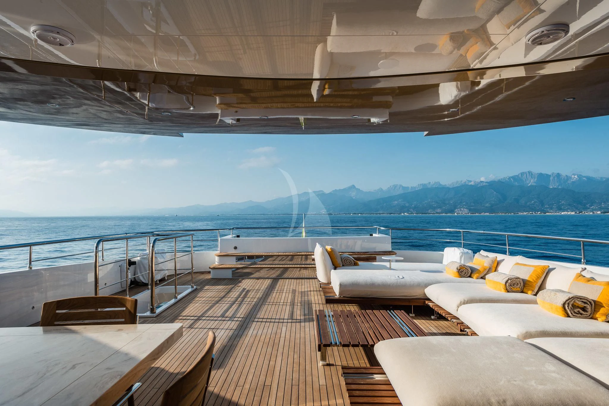 a deck with a view of the ocean and mountains aboard KIMOJO Yacht for Sale