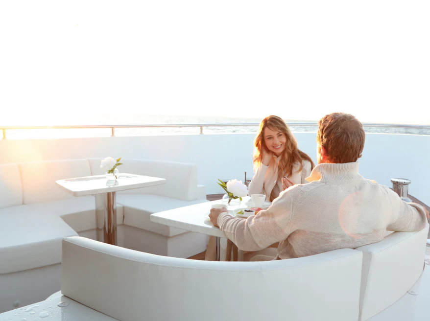 a man and woman sitting on a couch aboard NIRVANA II Yacht for Sale