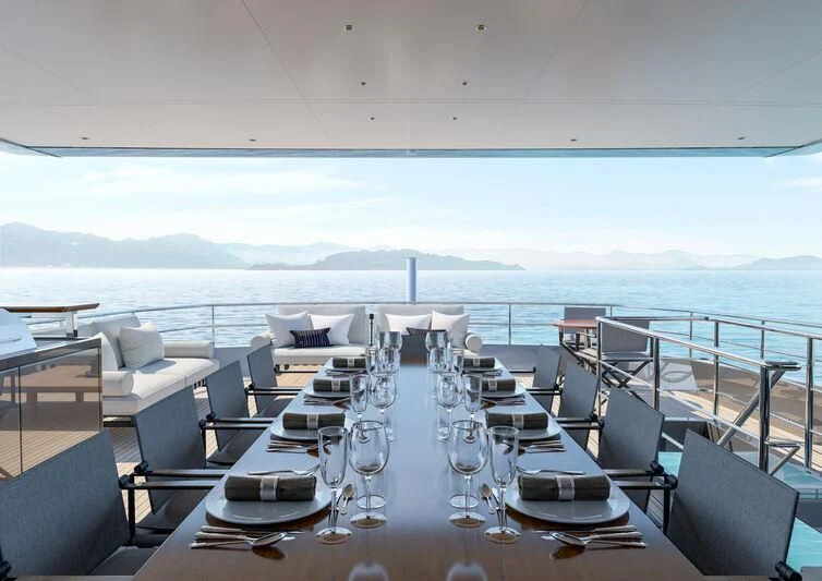 a large room with a table and chairs on it aboard NIRVANA II Yacht for Sale