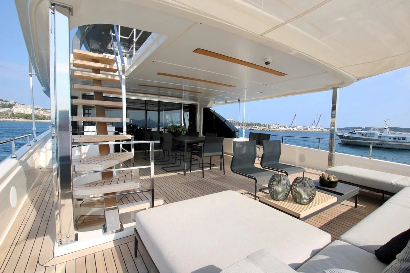 a room with a large window and a table with chairs and a pool aboard WILLPOWER Yacht for Sale
