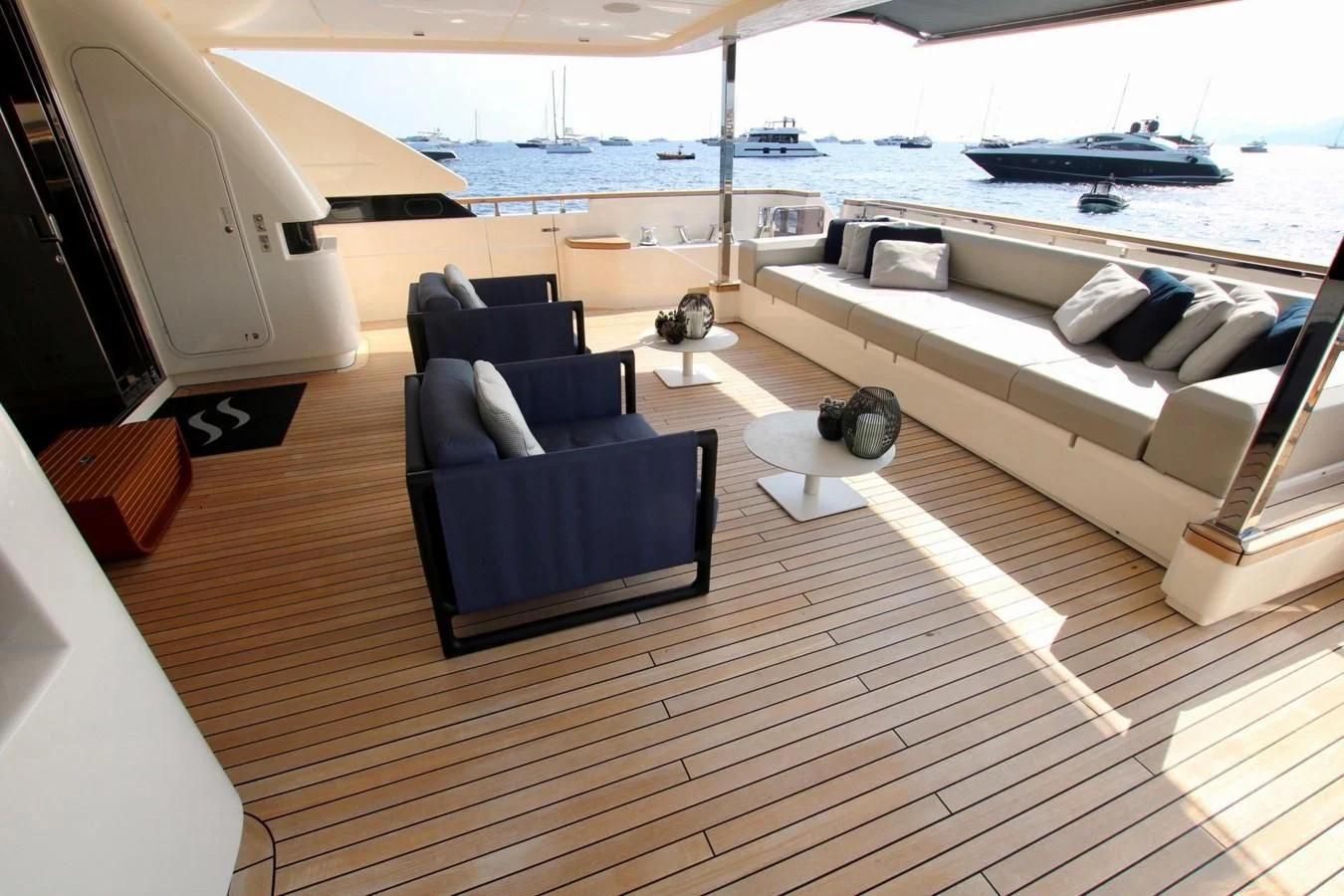 a room with a couch and a table and a boat in the water aboard WILLPOWER Yacht for Sale