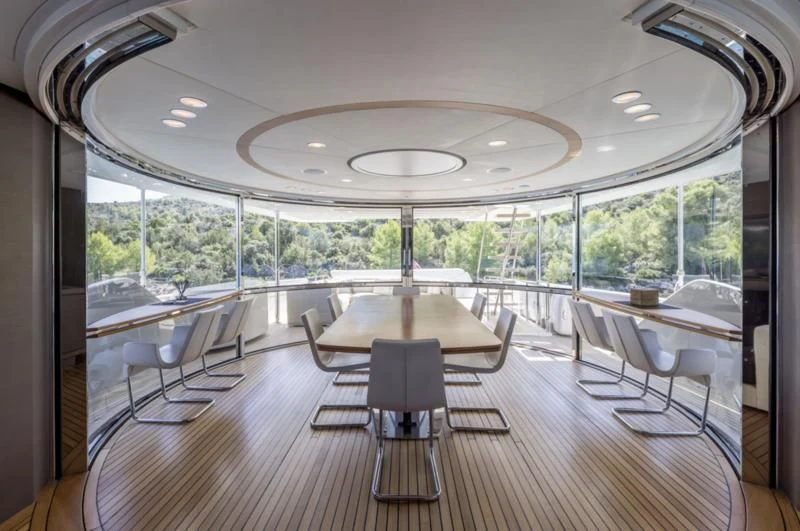 a room with tables and chairs aboard MANTA Yacht for Sale