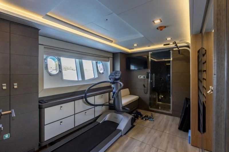 a room with a bed and a chair aboard MANTA Yacht for Sale