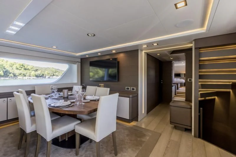 a dining table and chairs in a room with a view of the ocean aboard MANTA Yacht for Sale