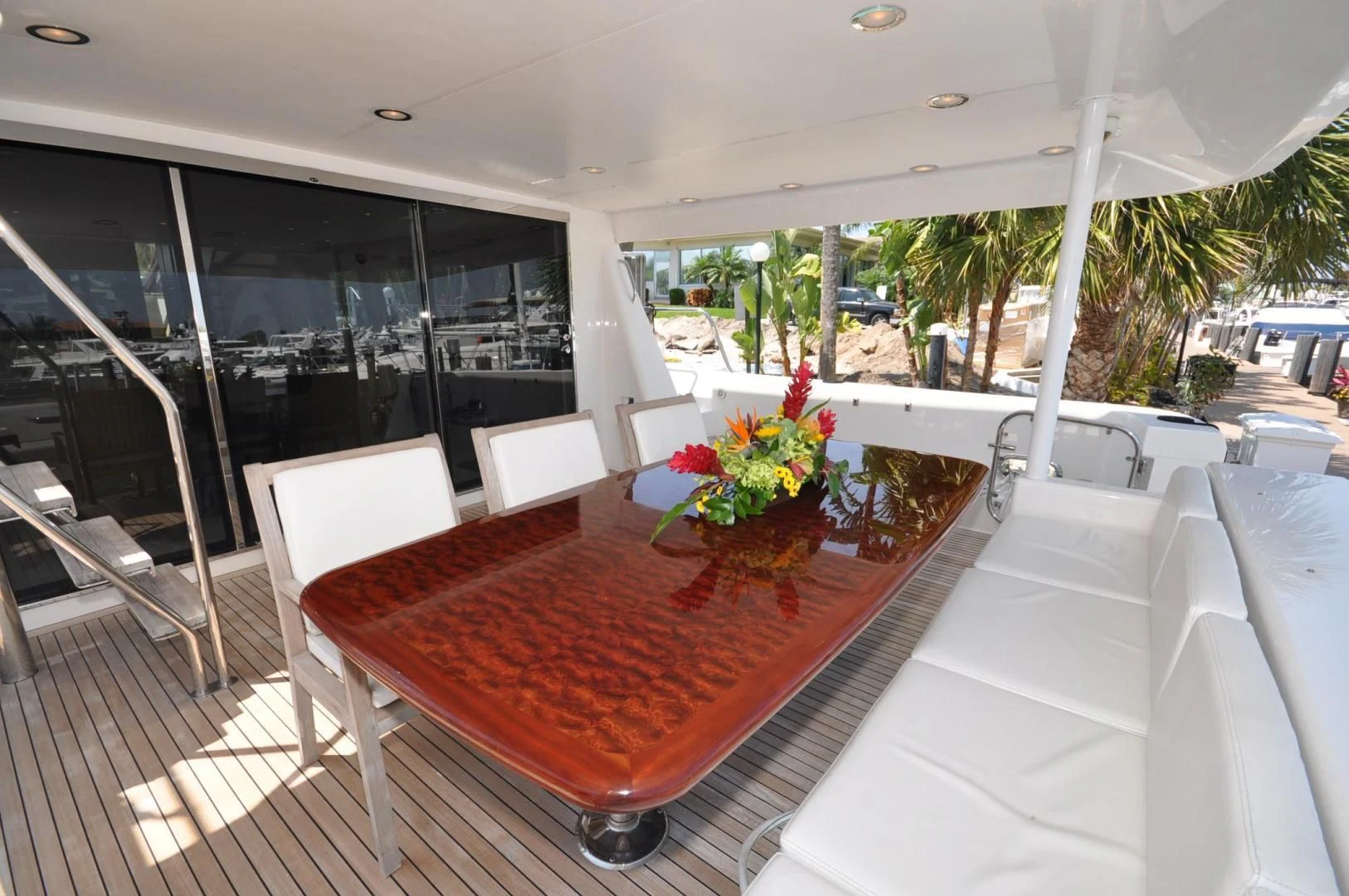 a table with chairs and a red table on a balcony aboard LUCK A LEE IV Yacht for Sale