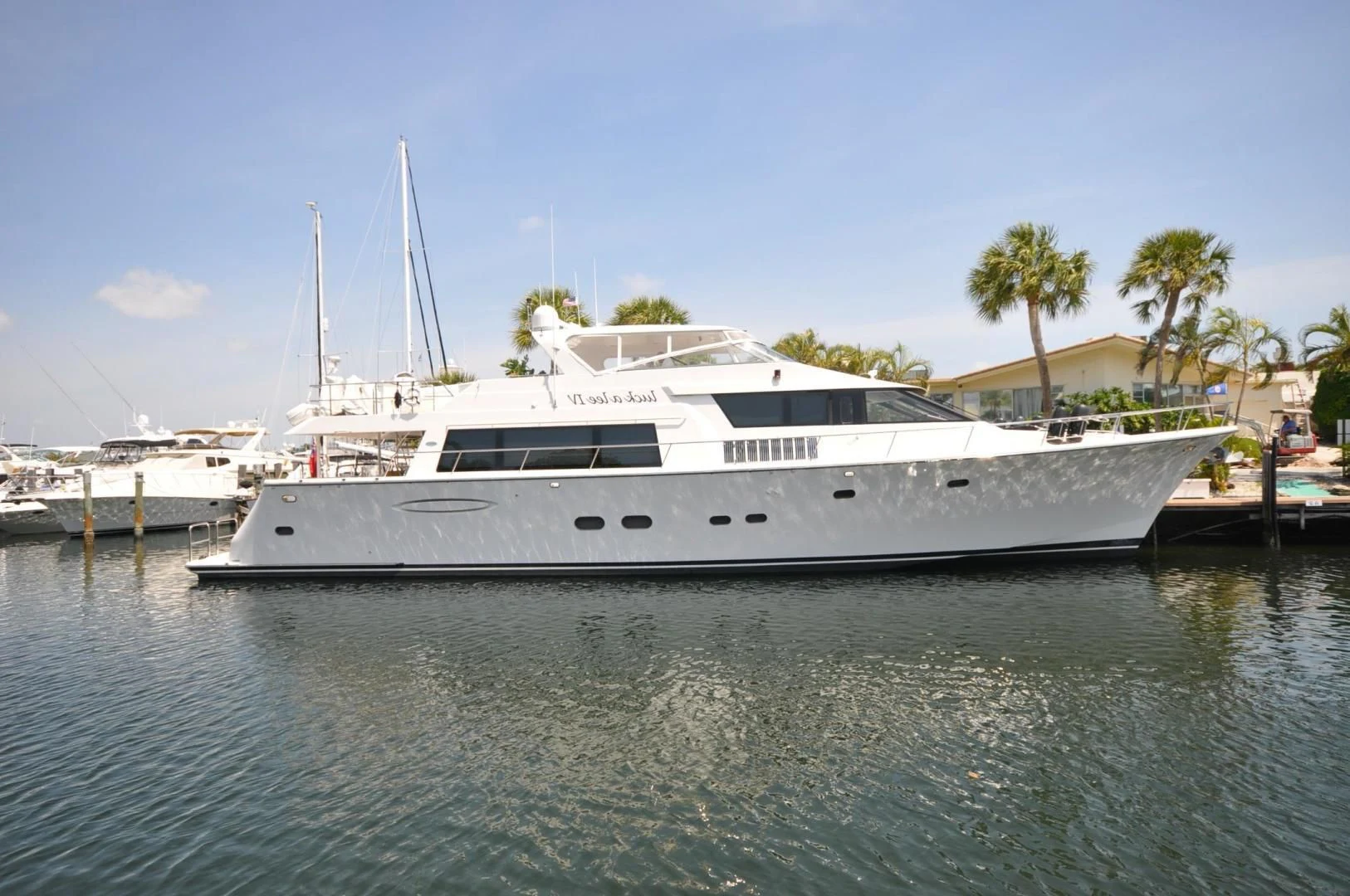 a white yacht in a harbor aboard LUCK A LEE IV Yacht for Sale