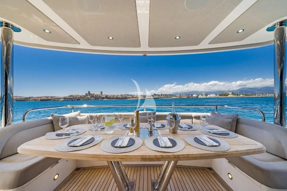 a table set for a meal on a balcony overlooking the ocean aboard TAKE OFF Yacht for Sale