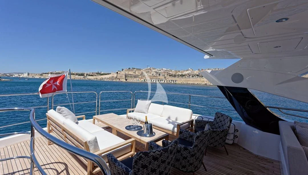 a table and chairs on a deck overlooking a large body of water aboard TAKE OFF Yacht for Sale
