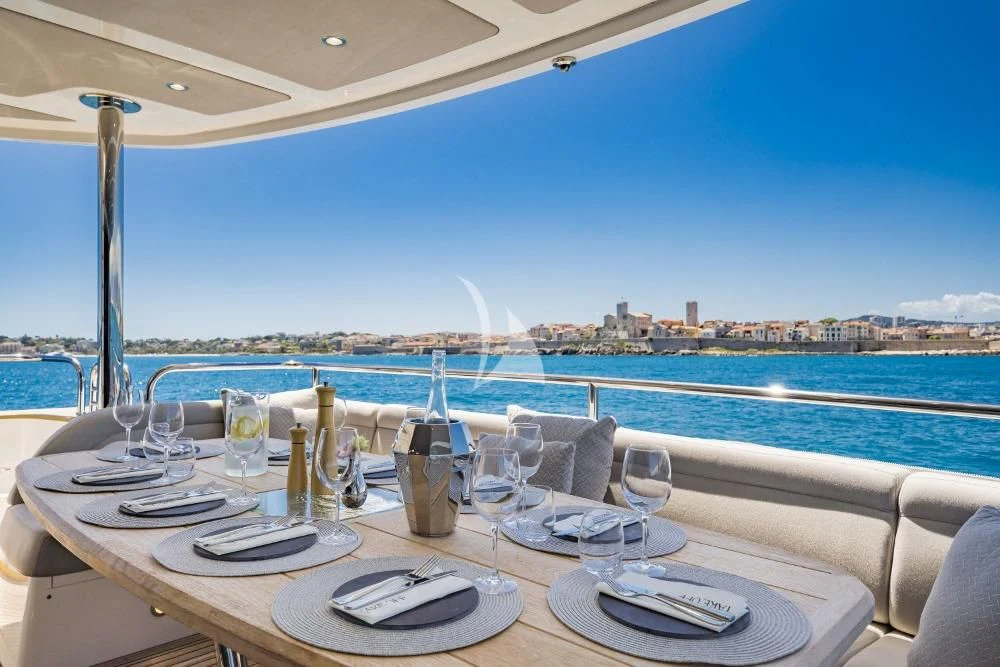a table set for a dinner on a balcony overlooking a city aboard TAKE OFF Yacht for Sale