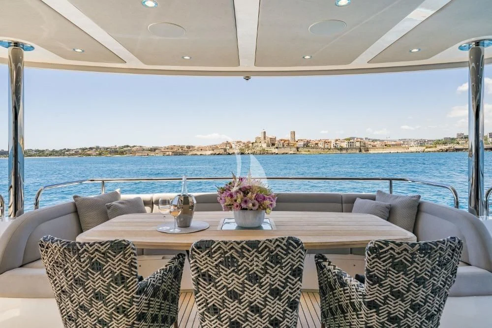 a table with chairs and a view of a city aboard TAKE OFF Yacht for Sale