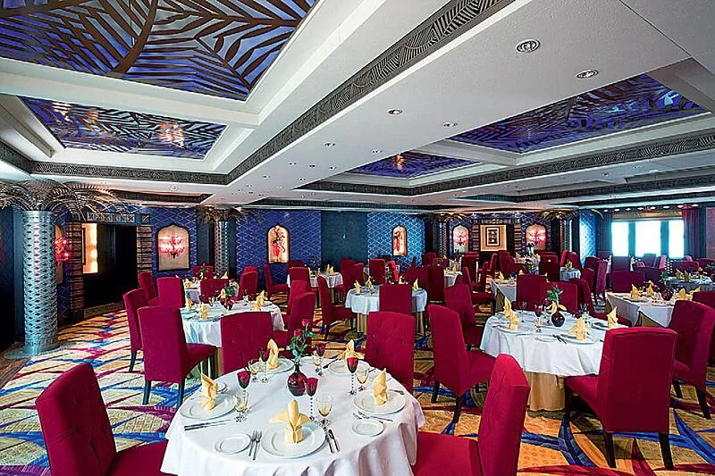 a room with tables and chairs aboard SCENIC ECLIPSE Yacht for Sale
