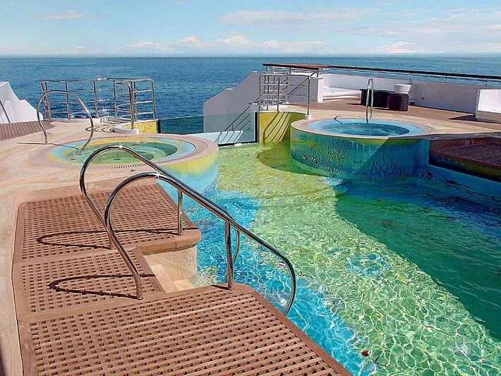 a large pool with a deck and a deck and a view of the ocean aboard SCENIC ECLIPSE Yacht for Sale