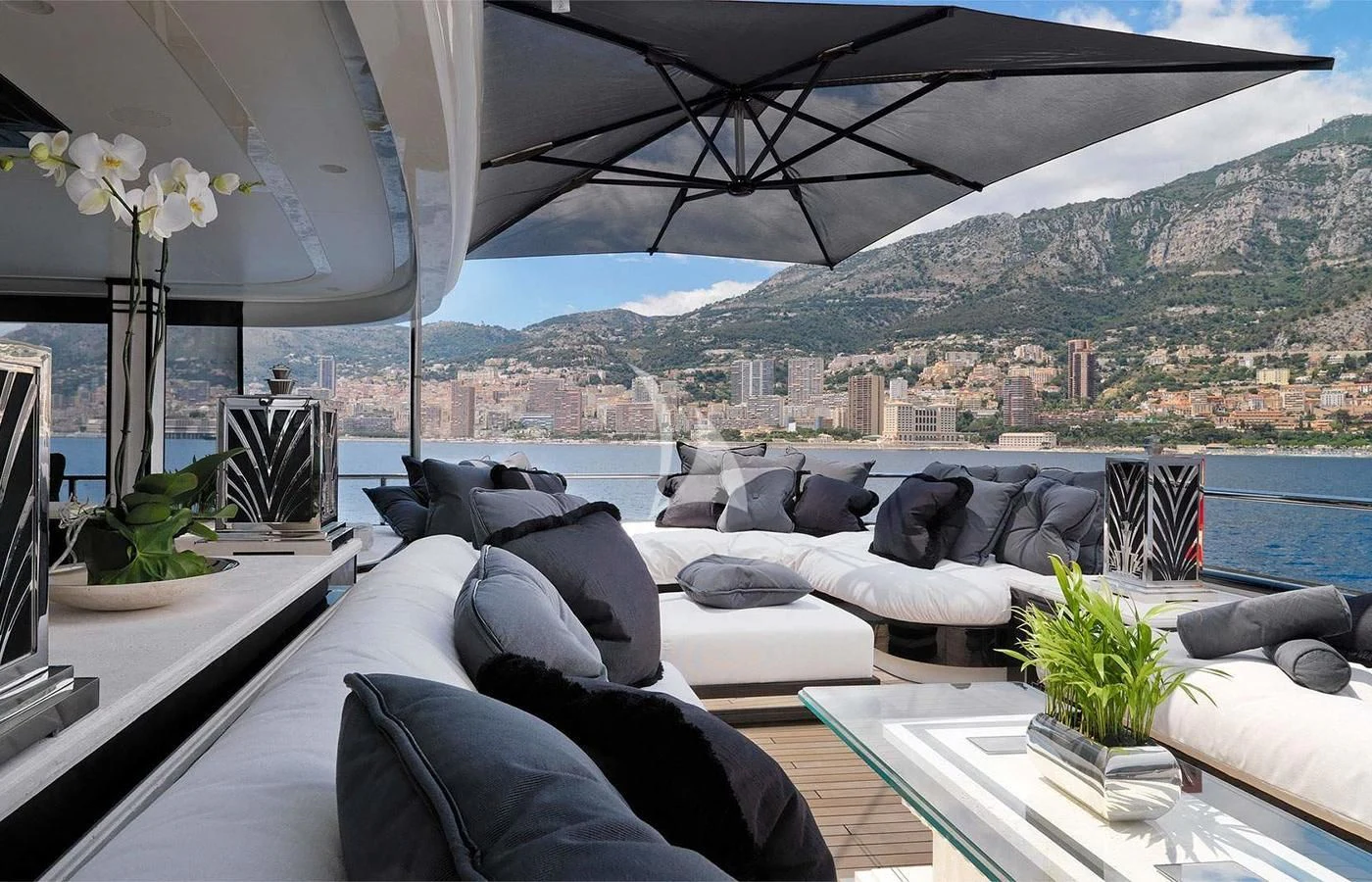 a room with a large bed and a large window with a view of a city aboard SILVER ANGEL Yacht for Charter