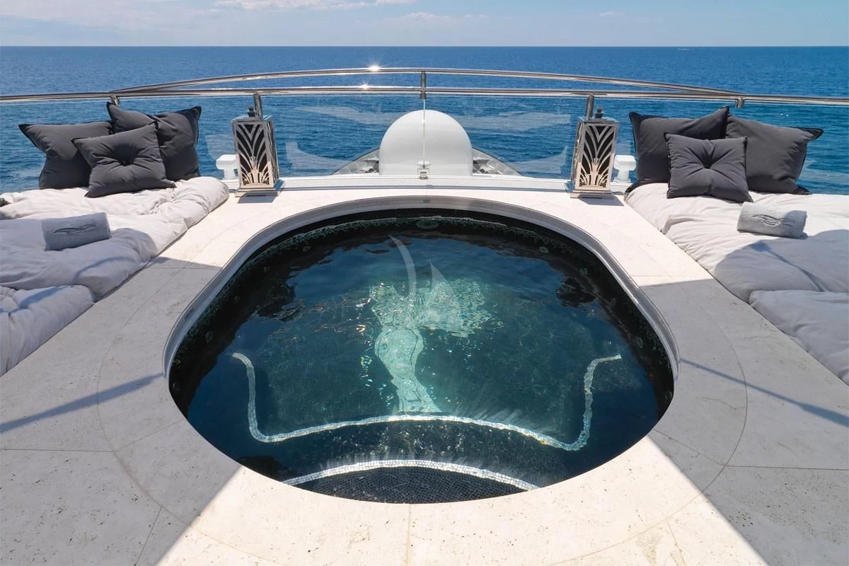 a pool with a large glass window overlooking a beach aboard SILVER ANGEL Yacht for Charter