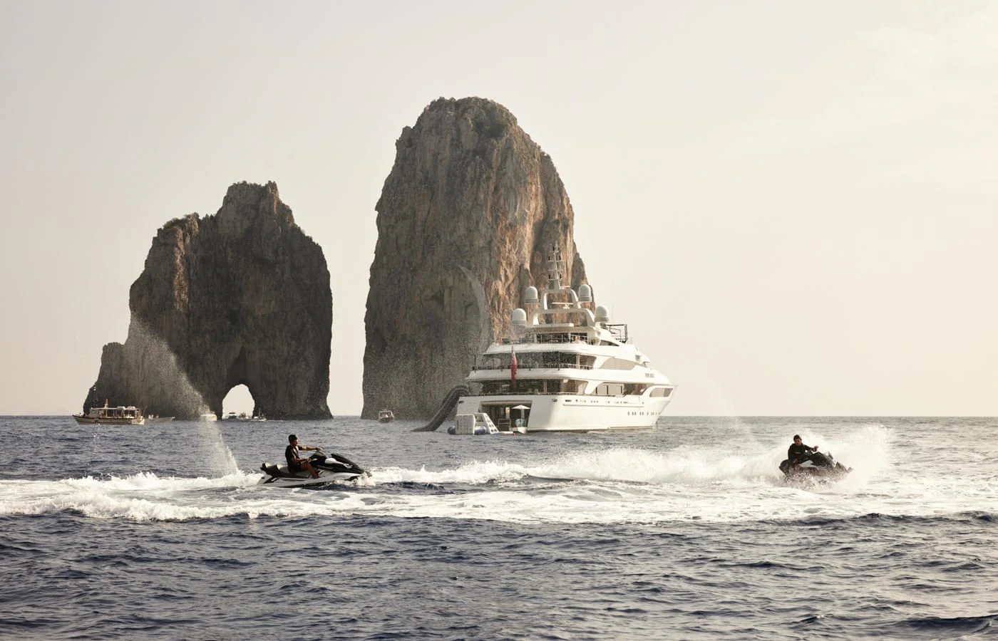 a boat in the water by a rock formation with Haystack Rock in the background aboard SILVER ANGEL Yacht for Charter