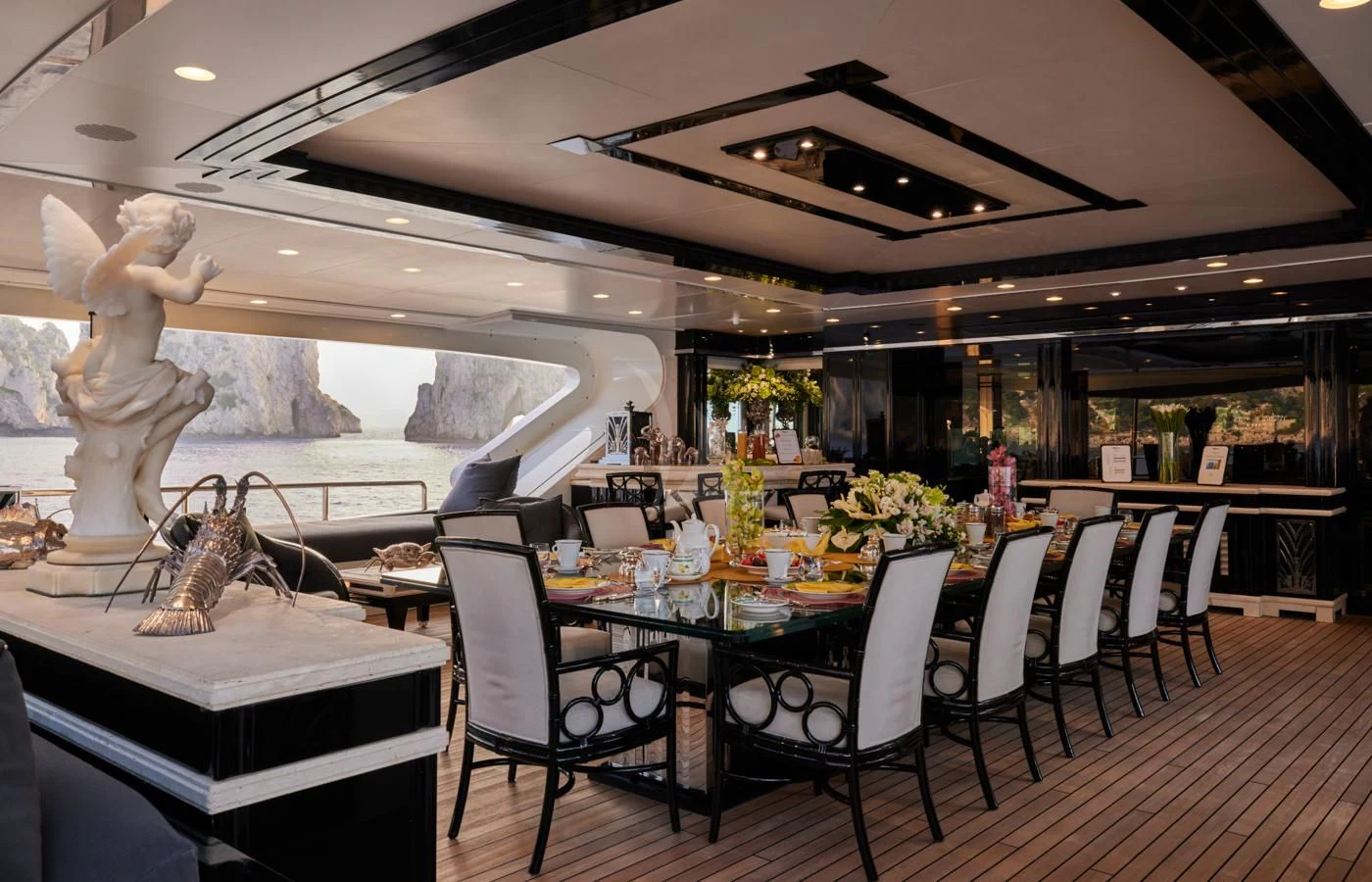 a large room with a table and chairs and a statue aboard SILVER ANGEL Yacht for Charter