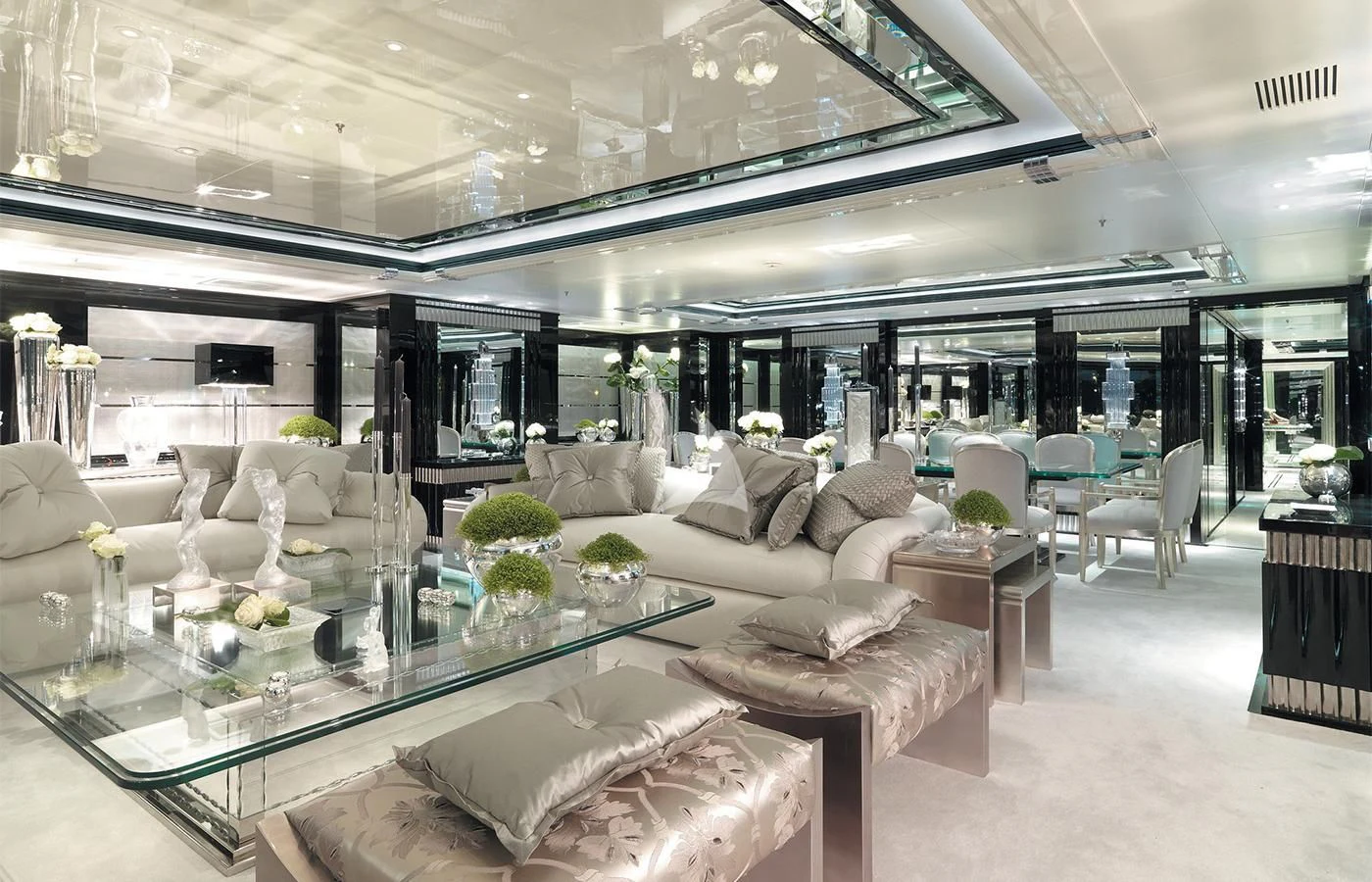 a large living room with a glass table and white couches aboard SILVER ANGEL Yacht for Charter