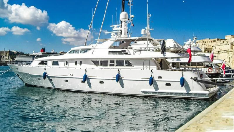 a white boat in a harbor aboard AMNA Yacht for Sale