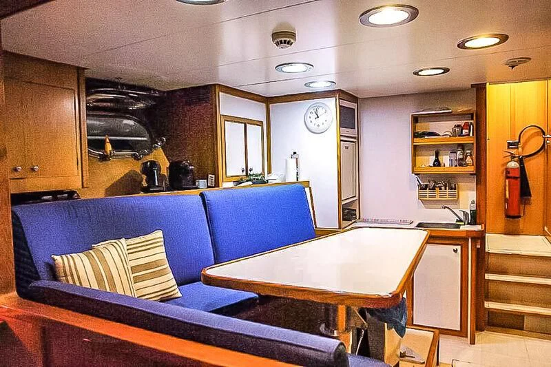 a kitchen with a blue couch aboard AMNA Yacht for Sale