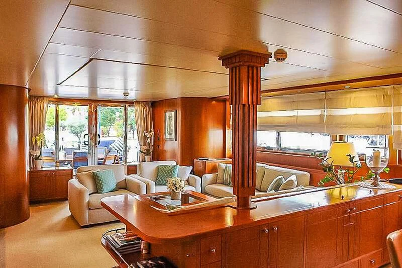 a large living room with a large wood table and a large window aboard AMNA Yacht for Sale