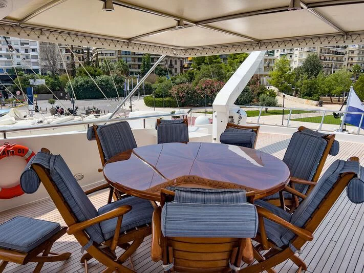 a table and chairs on a deck aboard AMNA Yacht for Sale