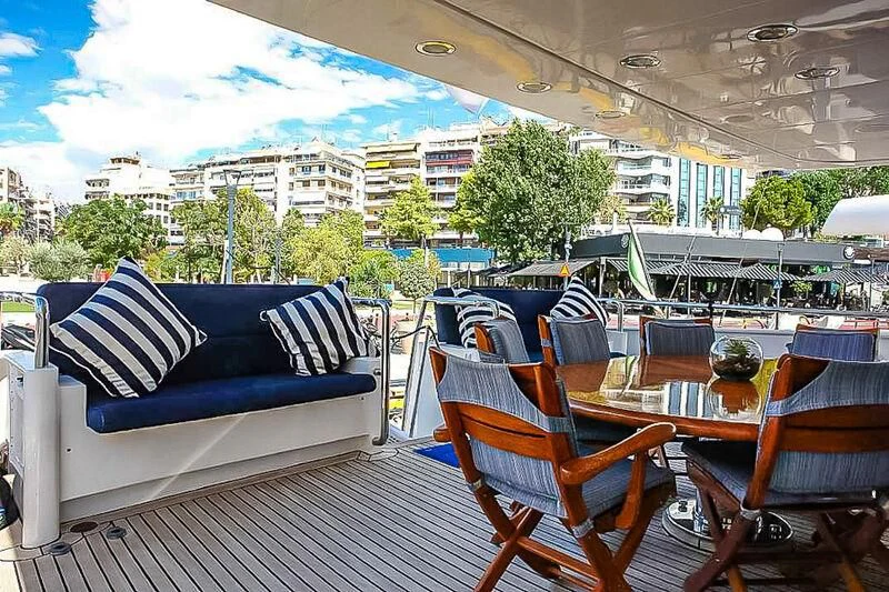 a deck with chairs and tables aboard AMNA Yacht for Sale