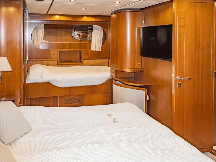 a hotel room with a bed and tv aboard AMNA Yacht for Sale