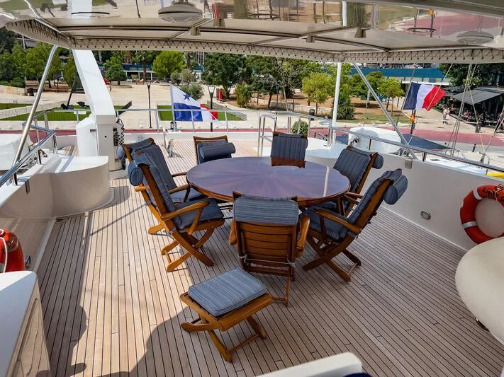 a table and chairs on a deck aboard AMNA Yacht for Sale